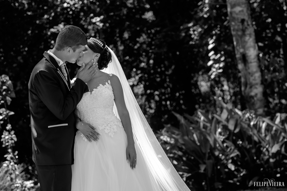 casal se beijando em frente às árvores em foto em preto e branco foto feita por felipe vieira fotógrafo de casamentos guarapari