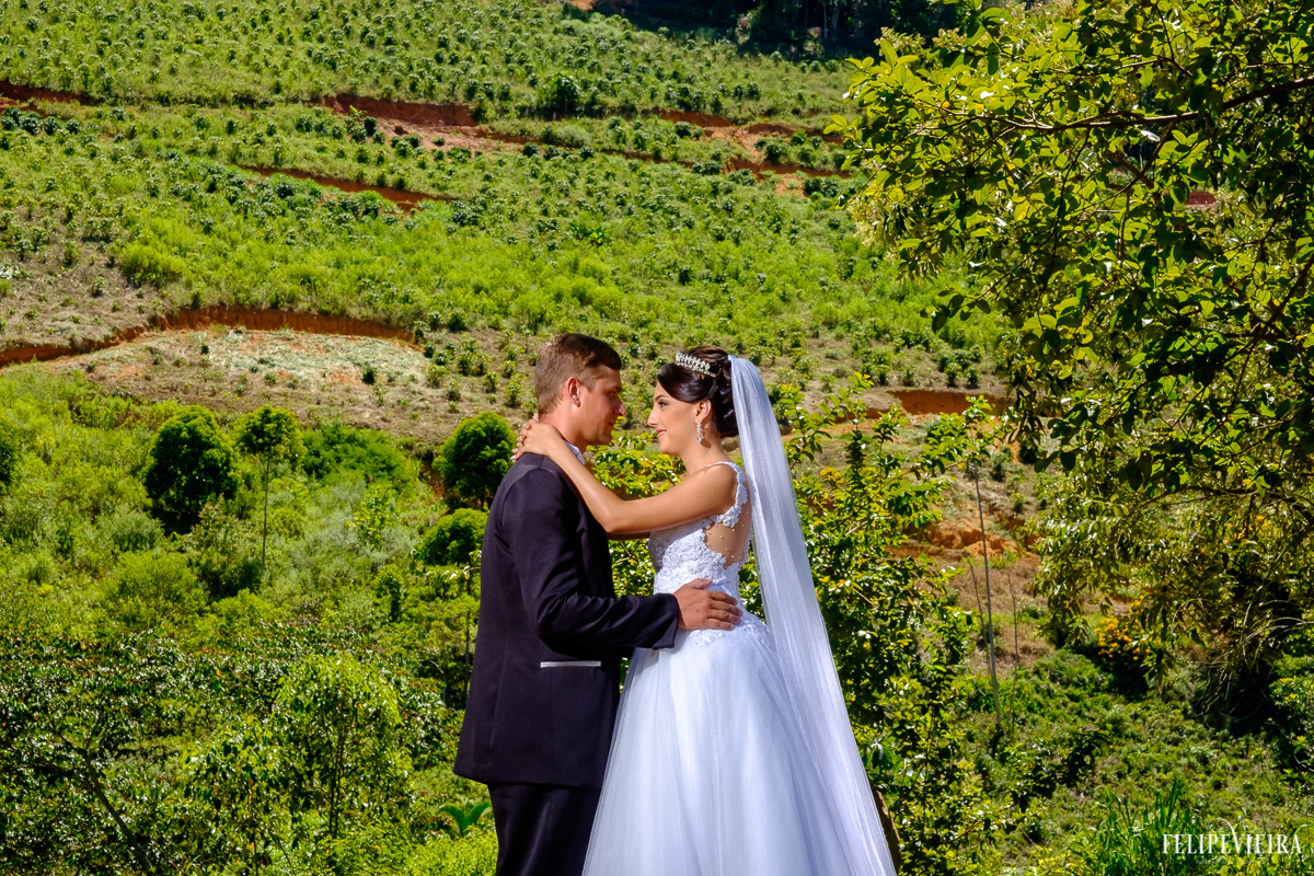 casal abraçado de frente em frente a um fundo bem verde foto feita por felipe vieira fotógrafo de casamentos guarapari