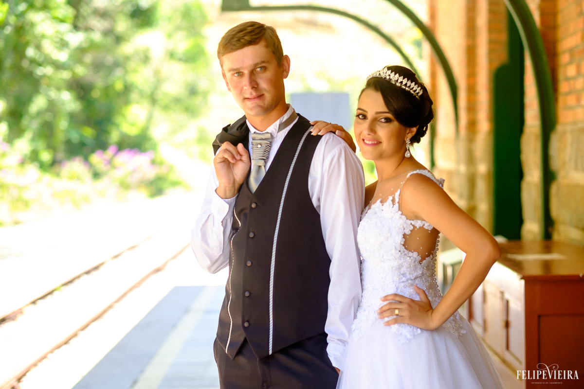 noivo segurando o blazer pelo ombro enquanto a noiva se apoia nele na estação de trens de matilde foto feita por felipe vieira fotógrafo de casamentos guarapari