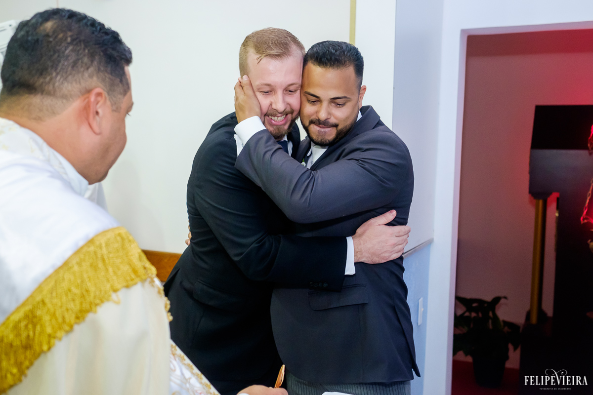 noivo abraça o padrinho durante a cerimonia de casamento na igreja santa rita em guarapari felipe vieira fotografia de casamento