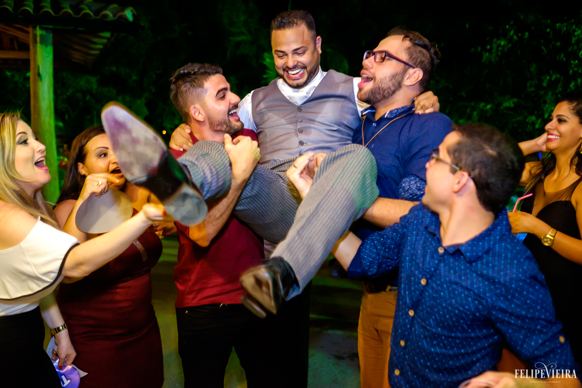 amigos do noivo pegam o noivo e levantam jogando para o alto e celebrando o casamento foto felipe vieira ofotografia do casamnt