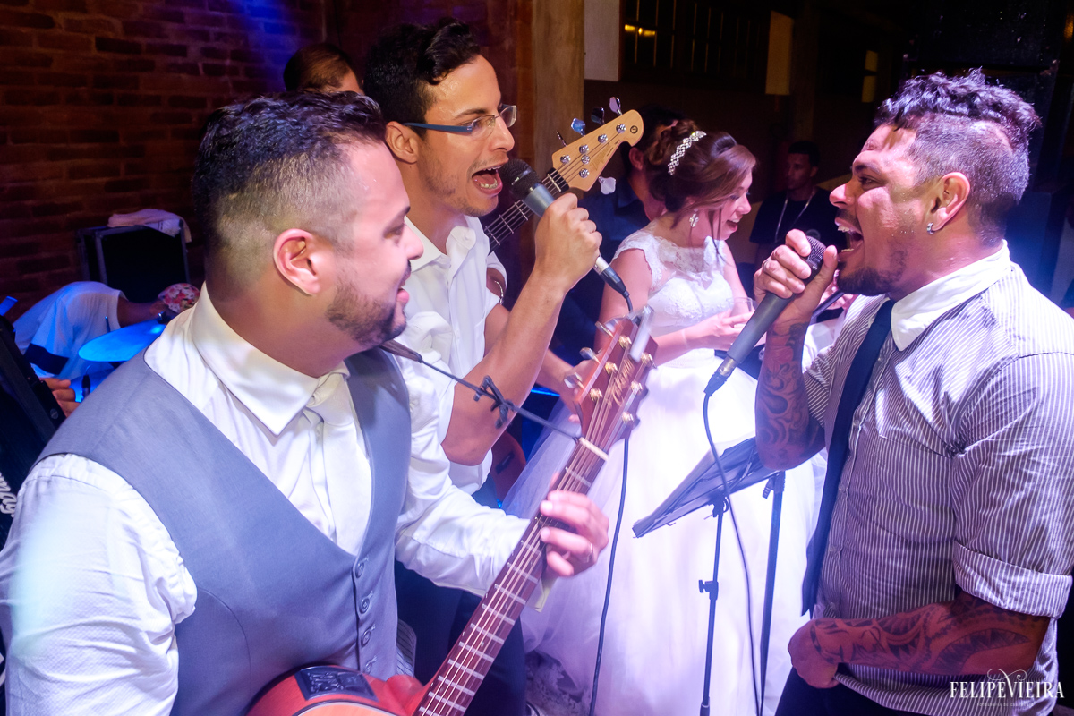 noivos cantando no palco junto com a banda na recepção do casamento felipe vieira fotografia de casamento