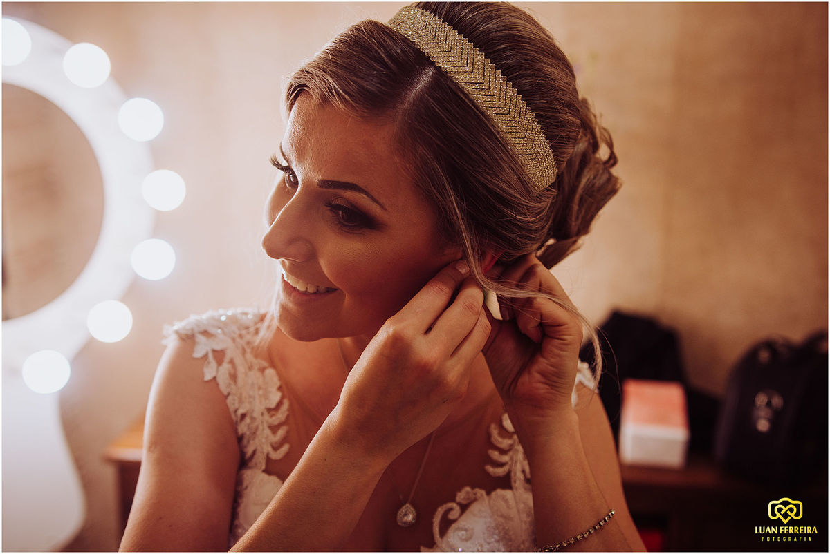 noiva se arrumando para o casamento na frete do espelho