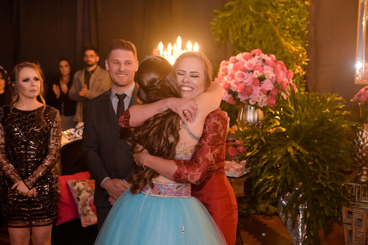 aniversariante de 15 anos abraçando a mãe