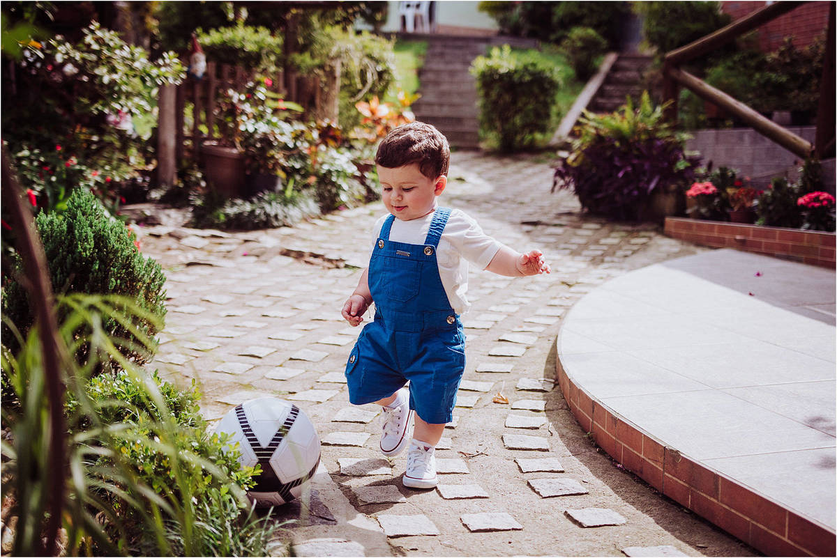 menino jogando bola no seu ensaio infantil no recanto da natureza em jaguaruna, santa catarina, fotografia 