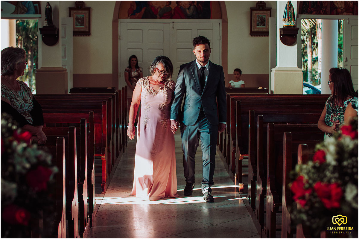 Noivo entrando na igreja com sua mãe 
