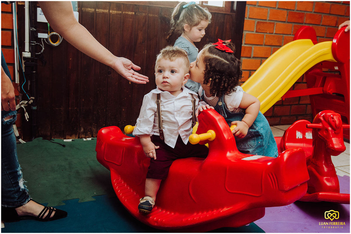 foto menino brincando e menina beijando ele