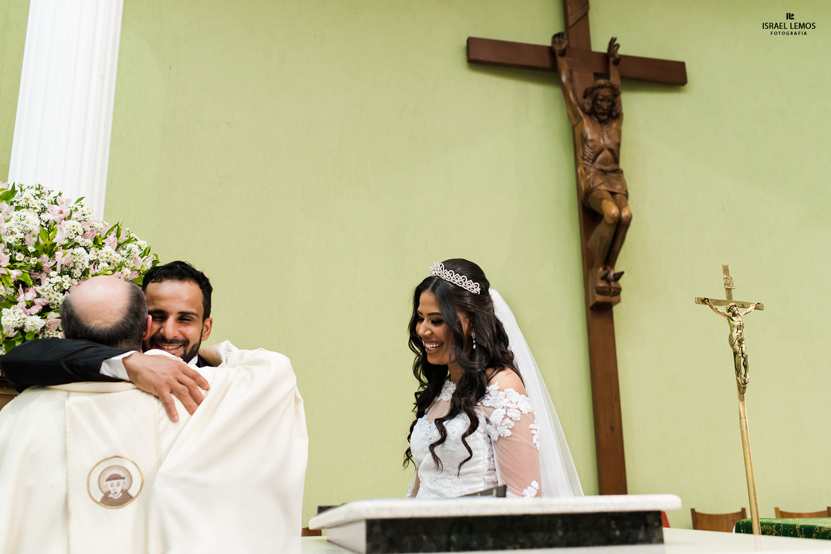 abraco do frei no noivo  na igreja Nossa senhora Auxiliadora em Para de Minas MG fotos feitas pelo fotografo de casamento de Para de Minas Israel lemos