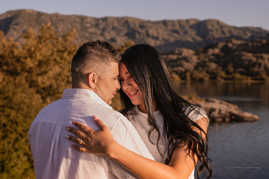 pareja abrazándose y celebrando su boda elopement al aire libre. Al fondo se ve el lago y las montañas