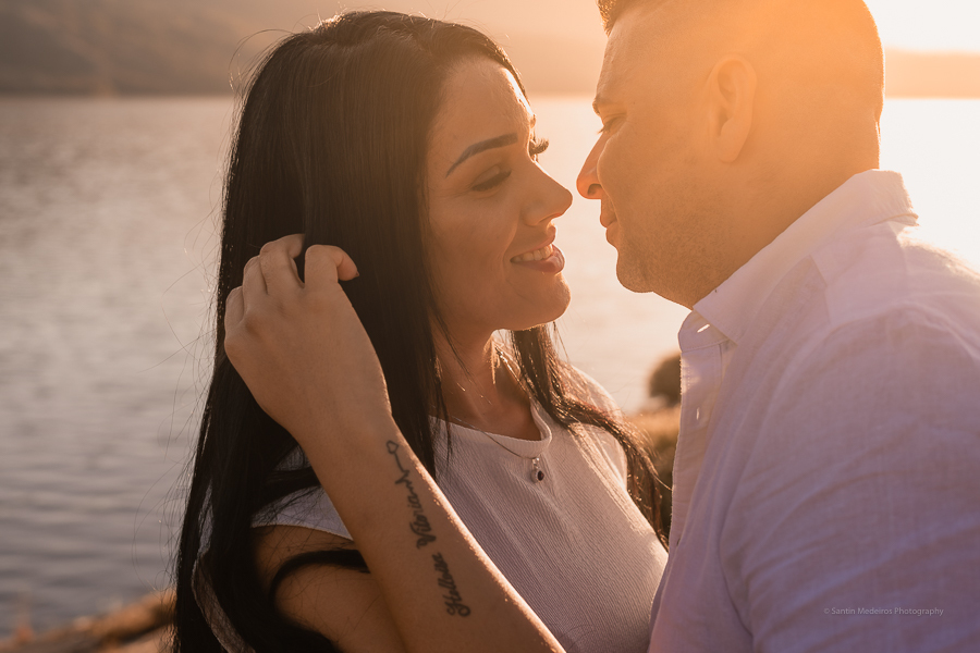 pareja abrazándose y celebrando su boda elopement al aire libre. Al fondo se ve el lago y la luz dorada del sol tocando sus rostros.