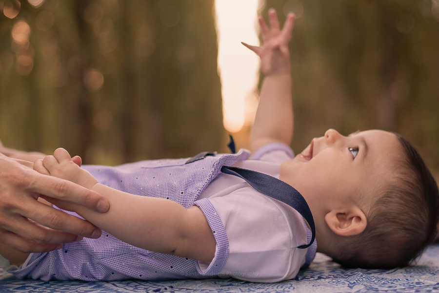 bebe tumbado en la mesa del parque de la mano (izquierda) con su madre y su brazo derecho hacia al cielo