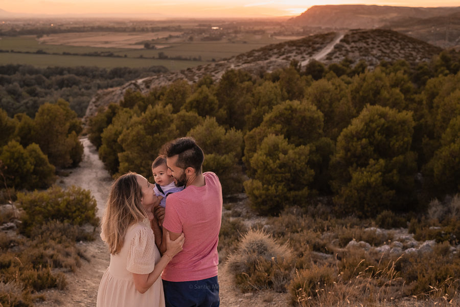 familia en lo alto de la montaña jugando y viendo la puesta del sol