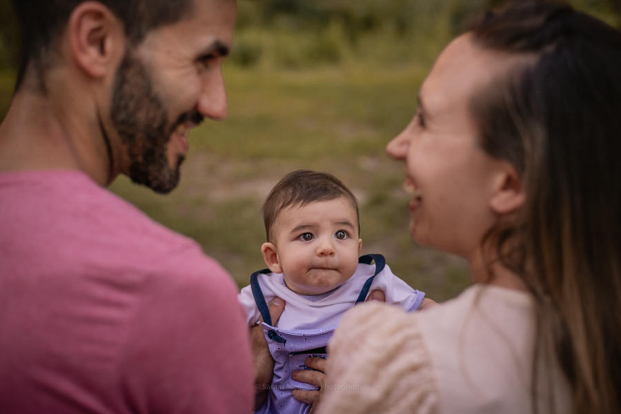 bebe mirando a sus padres que se ríen un montón