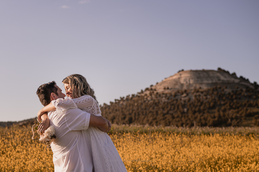 novia en brazos de su marido un campo de flores amarillas
