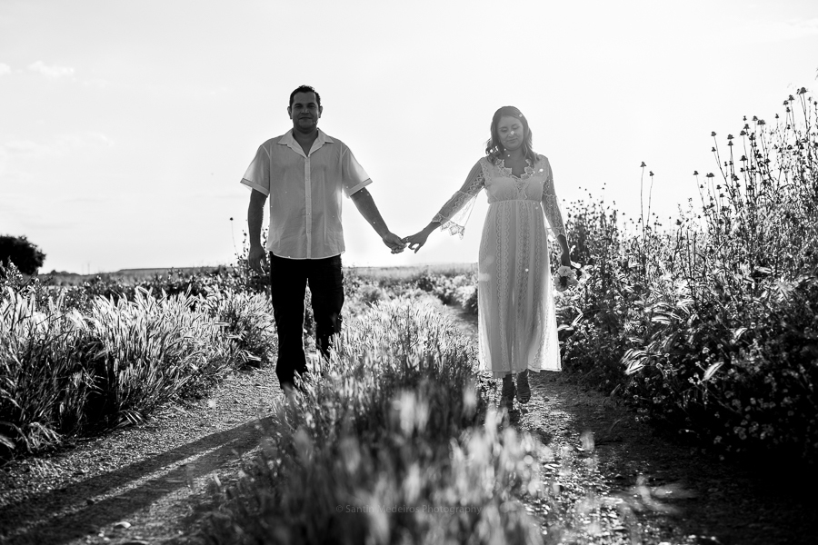 fotografía en blanco y negro: pareja andando de las manos por un camino de tierra