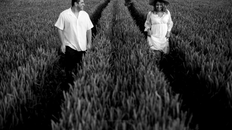 fotografía en blanco y negro: pareja corriendo por un camino de amapolas