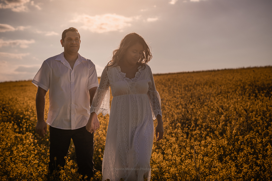 pareja andando de las manos con el sol al fondo