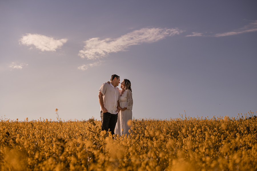 pareja riéndose en un campo de flores amarillas