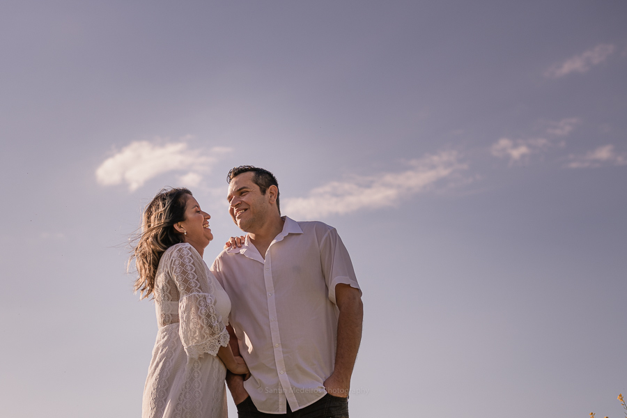 pareja riéndose con el cielo azul de fondo