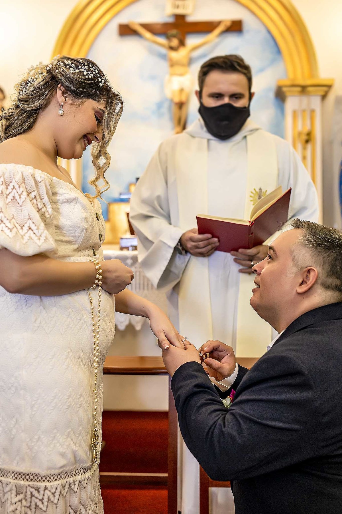 Fotografia do momento que o noivo Milson se ajoelha na Igreja para colocar a aliança na sua noiva, na cerimônia religiosa e registrada pelo fotógrafo George Dantas