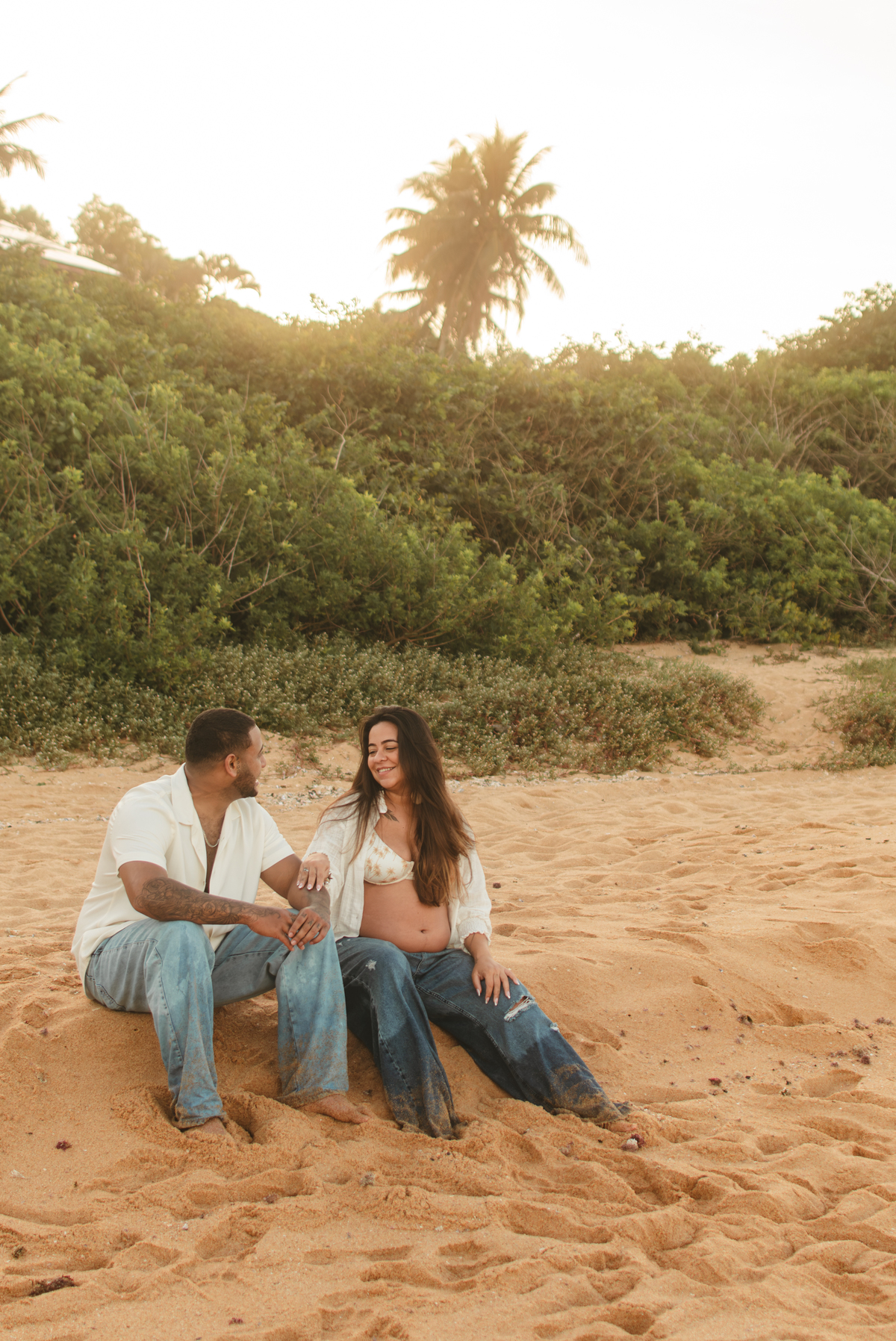 Casal apreciando o pôr do sol durante ensaio de gestante em Guarapari ES.