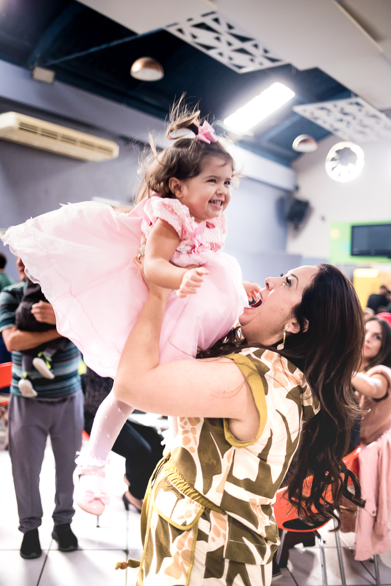 abraçando a bebê de vestido rosa