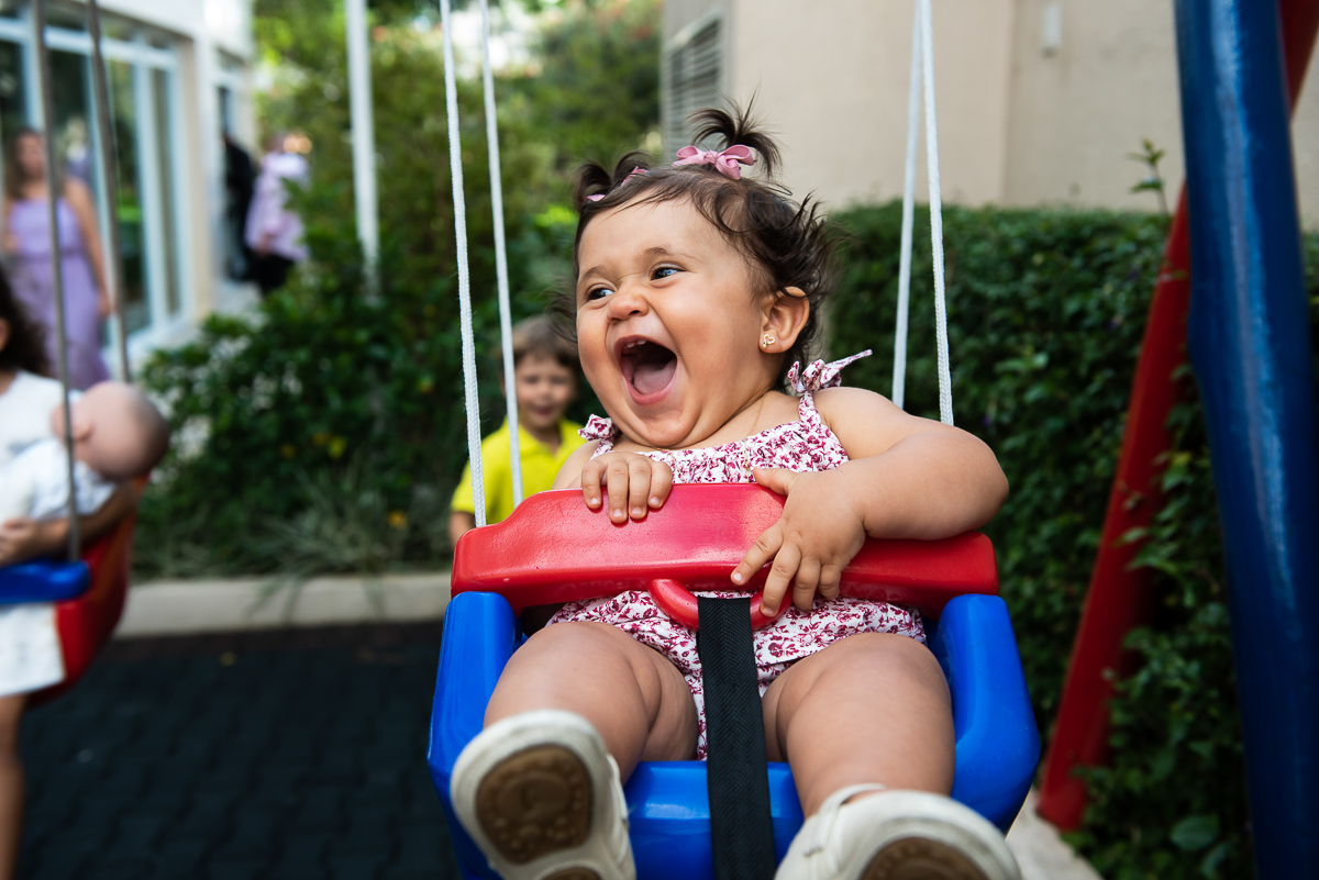 criança divertindo no balanço azul e vermelho