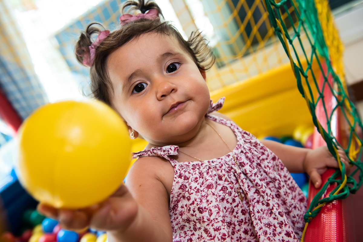 menina com bola amarela na piscina de bolinha