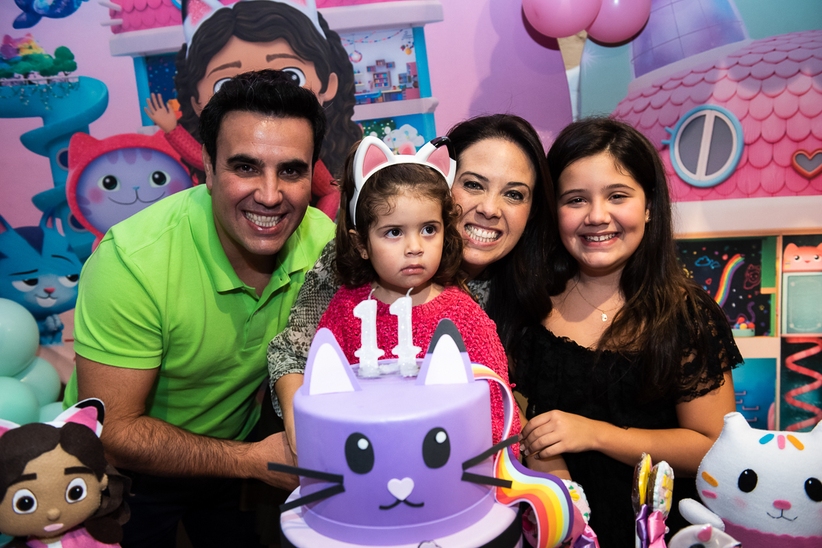 família feliz na frente do bolo