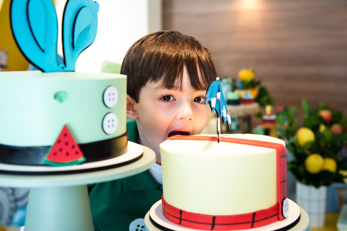 menino mordendo o bolo do aniversário