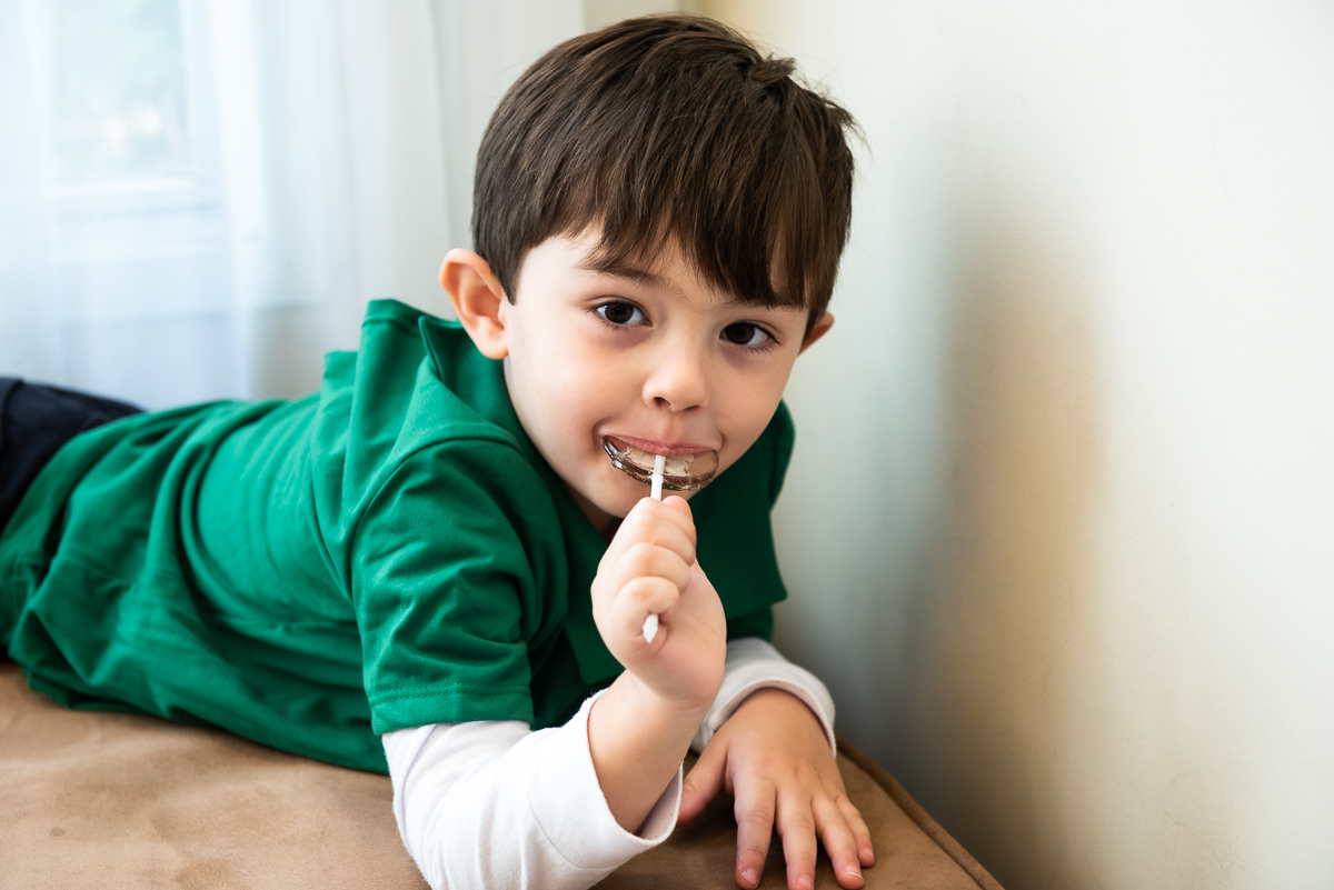 menino de verde chupando pirulito