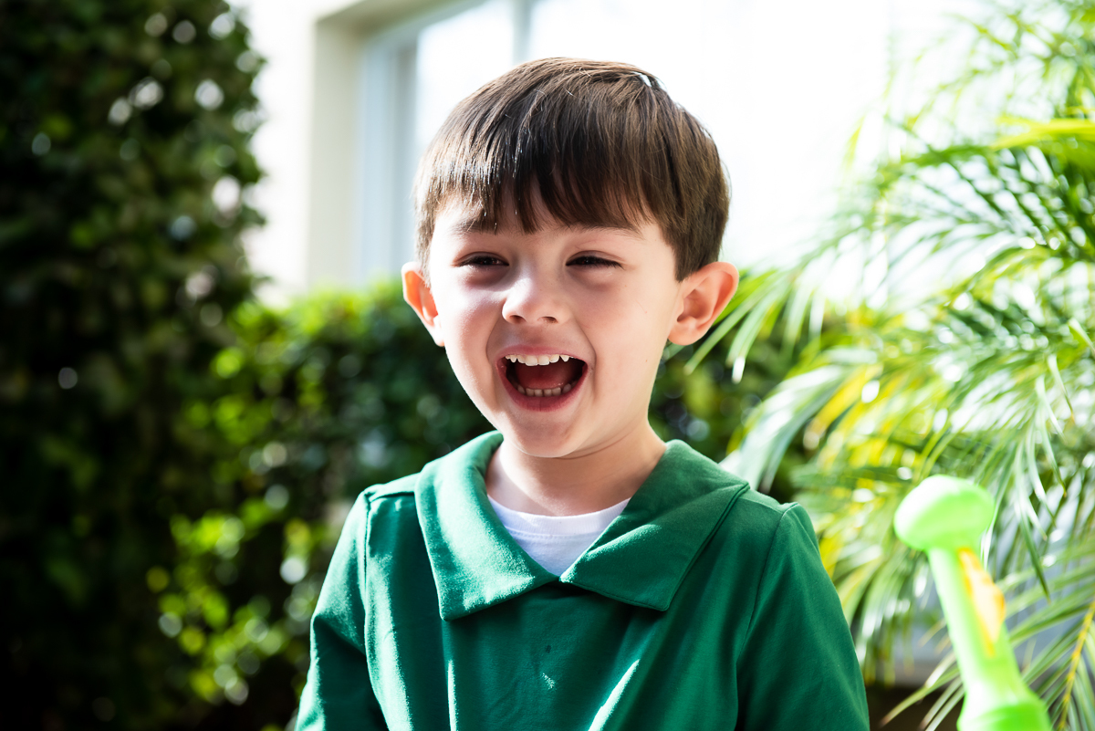 menino de blusa verde gritando de alegria