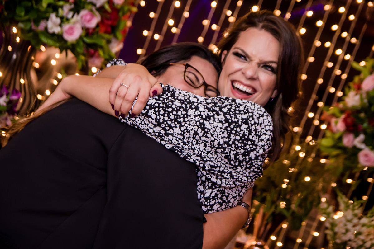 mulher com óculos abraçando a aniversariante