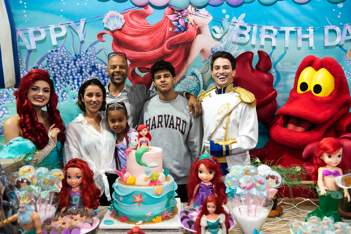 família reunida com os personagens do desenho pequena sereia para cantar os parabéns