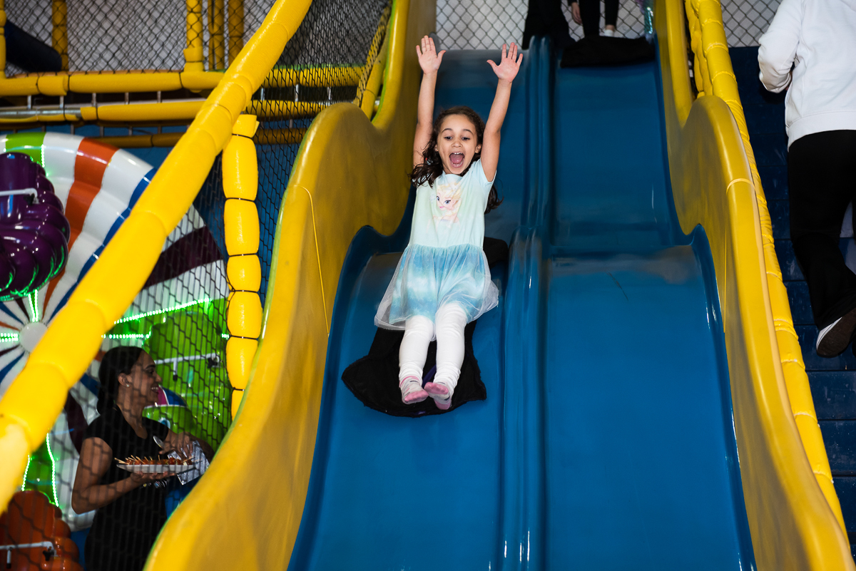 mais uma criança descendo o tobogã azul de corrimão amarelo