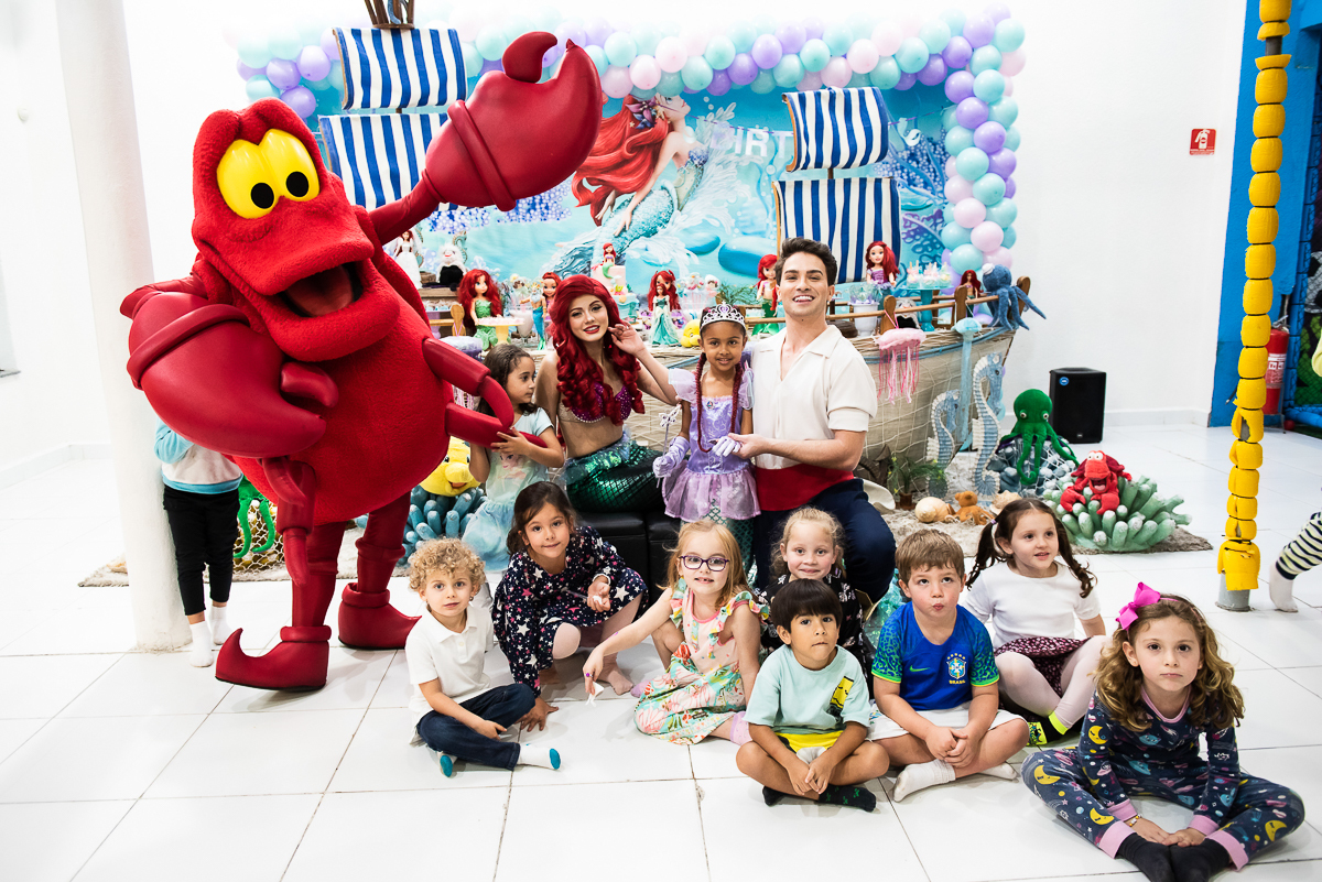 A turma toda do desenho Pequena Sereia tirando fotos com as crianças