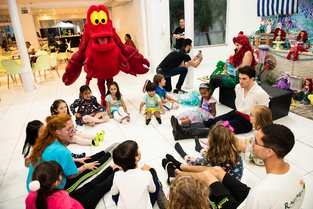 Caranguejo Sebastião conversando com a roda de crianças e adultos