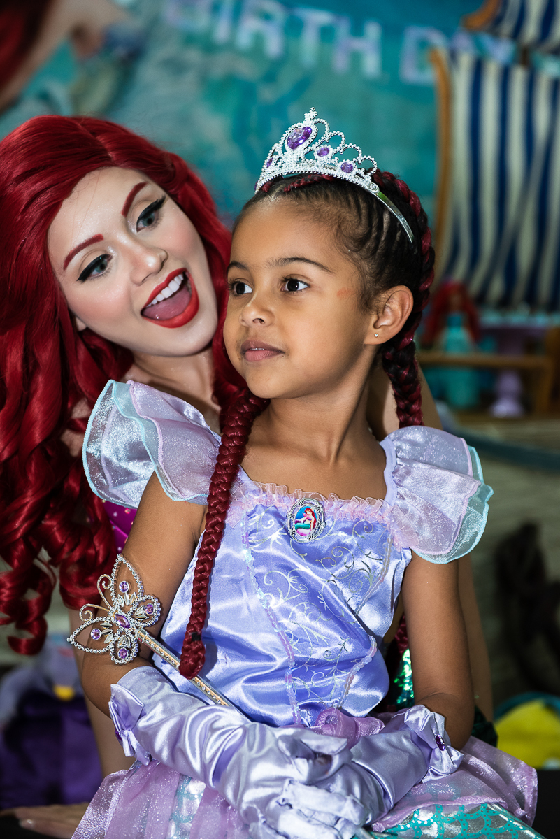 Ariel, a Pequena Sereia, contando história para a linda menina de vestido lilás