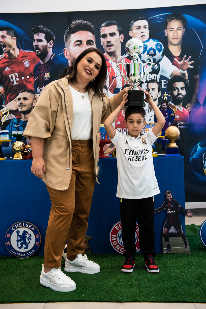 mamãe e criança com a taça de campeão em cima da cabeça
