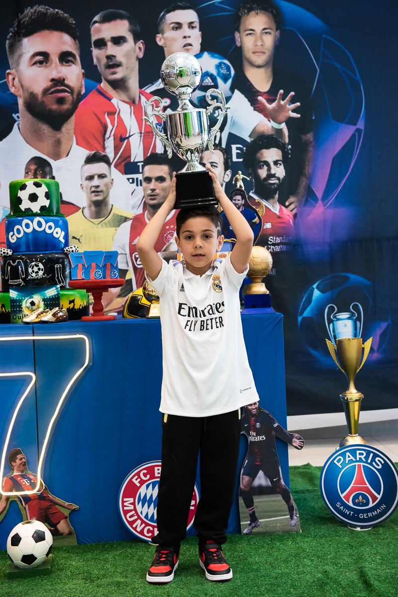 menino com o troféu na cabeça