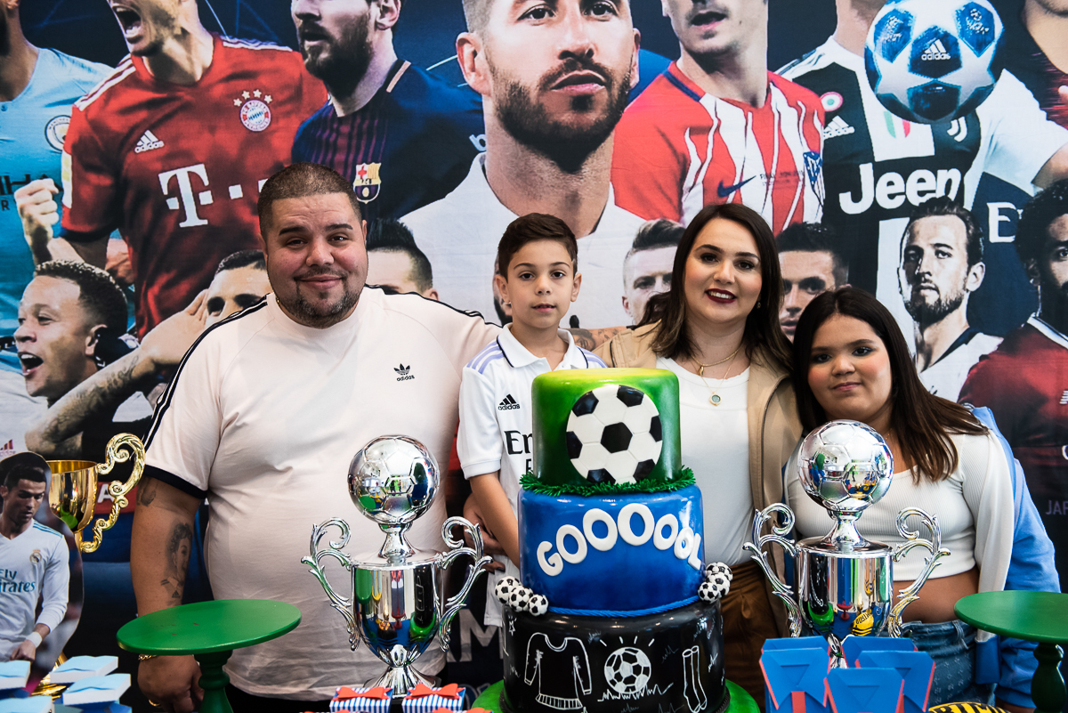 pai, menino, mãe e menina tirando foto na mesa de parabéns