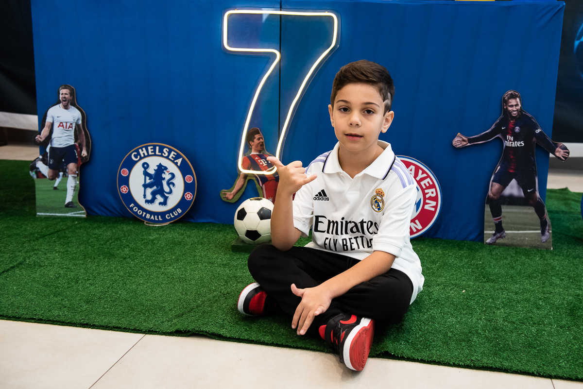 criança sentada na grama sintética