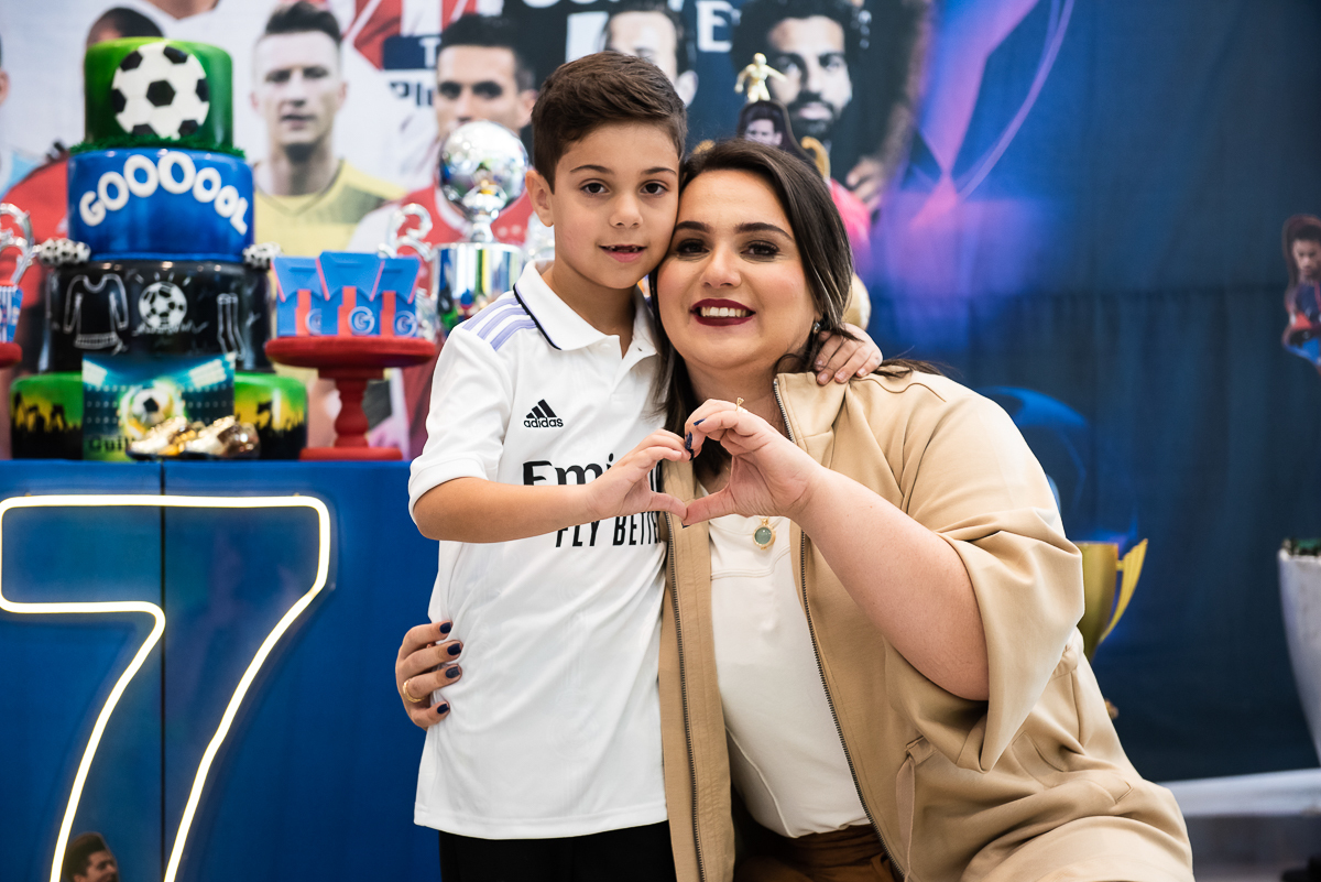 menino e mamãe fazendo símbolo de coração com as mãos