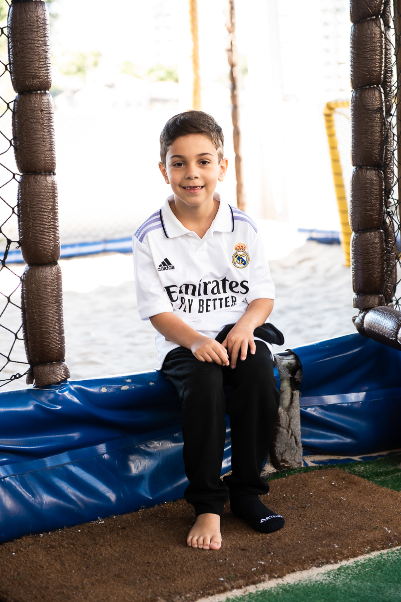 sentado esperando para começar a jogar na quadra de futebol de areia