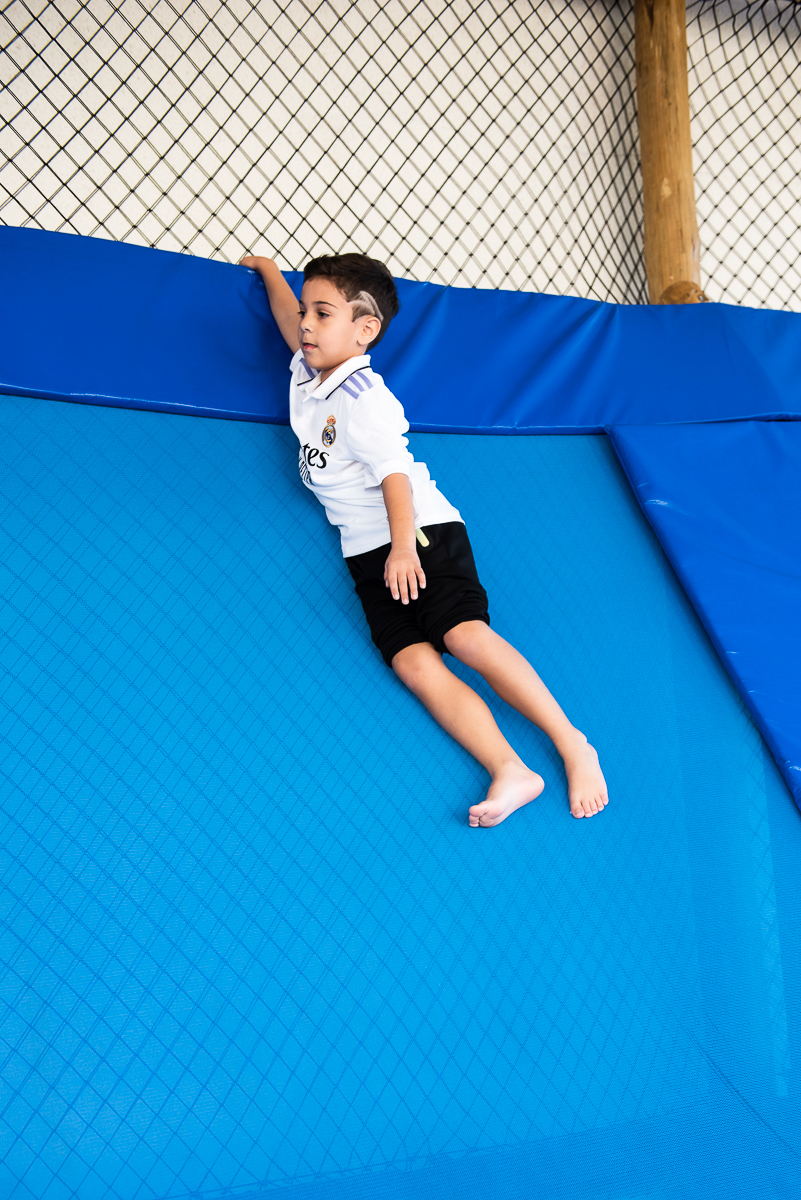 menino descendo o brinquedão azul