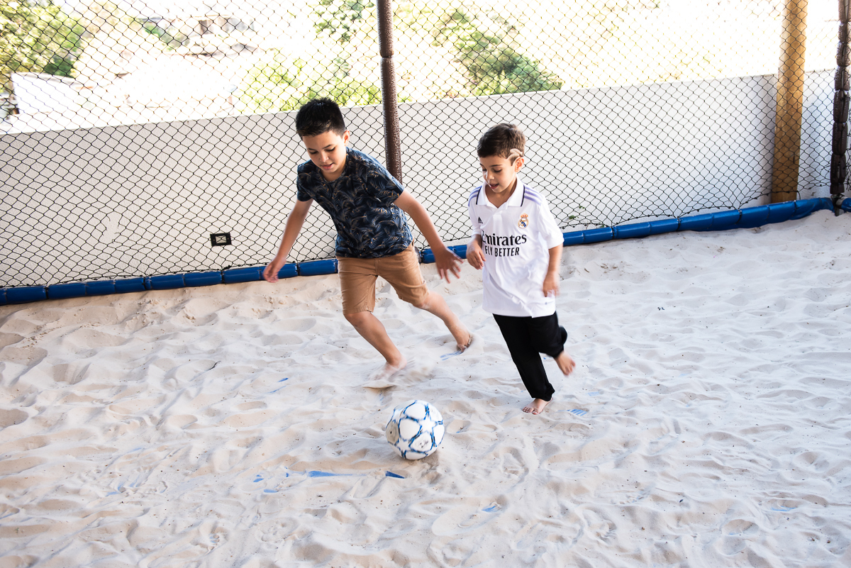 disputa de bola entre dois meninos no campo de areia
