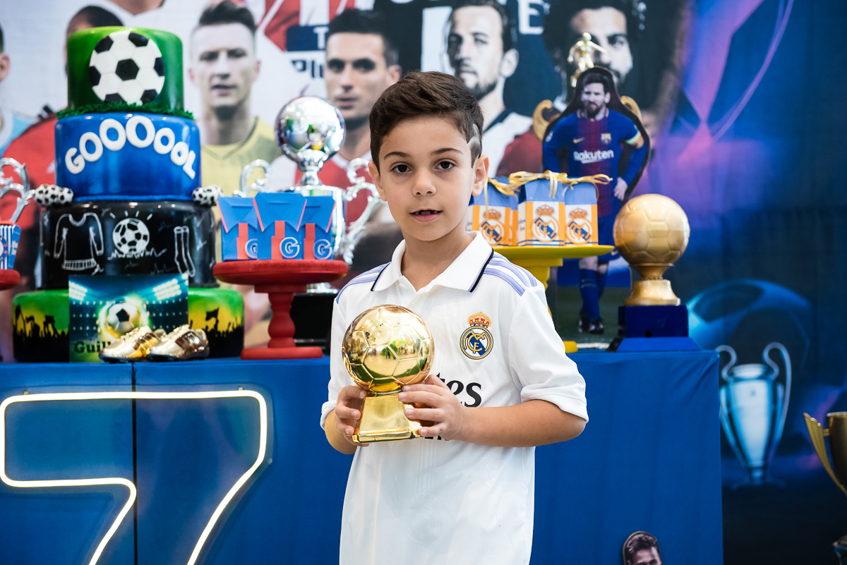 criança com a taça de campeão na mão