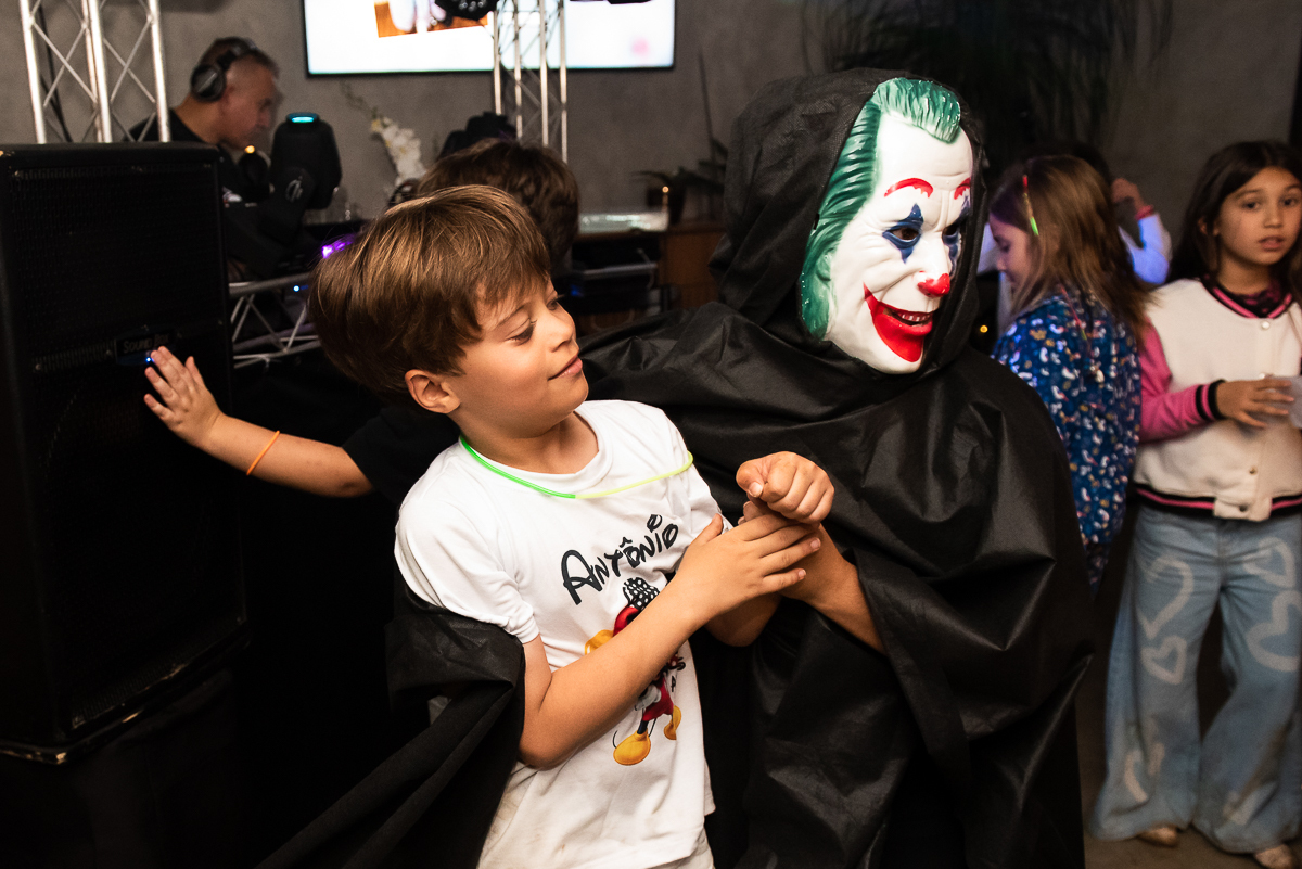 palhaço fantasma abraçando o menino