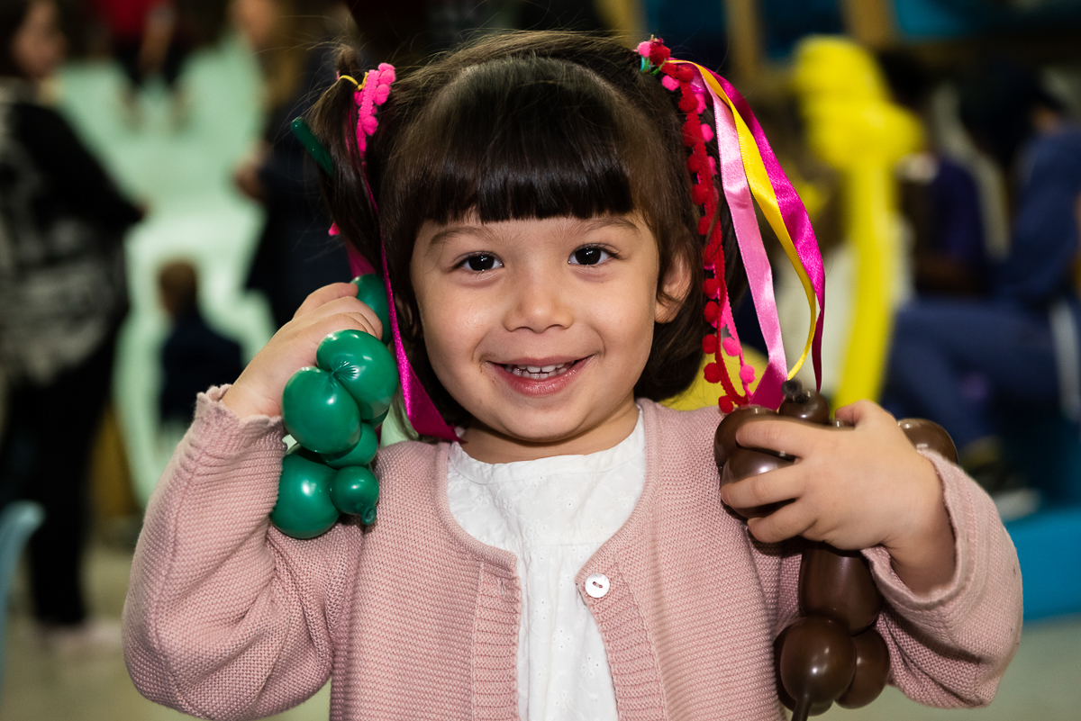 menina de laço na cabeça curtindo o aniversário