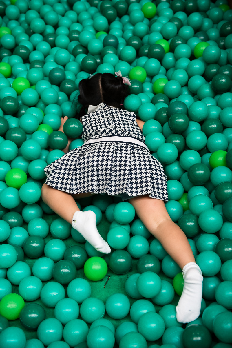 menina nadando na piscina de bolinha verde